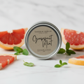 Grapefruit Mint gift tin propped upright on pale marble