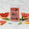 Grapefruit Mint wax melt propped upright on pale marble