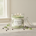 Lit Huckleberry and Thyme three-wick candle with propped glass lid
