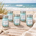 Six Sun-Kissed Linen mini candles standing upright on a beachside tabletop