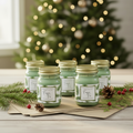 Six upright Fraser Fir mini mason candles on a holiday surface